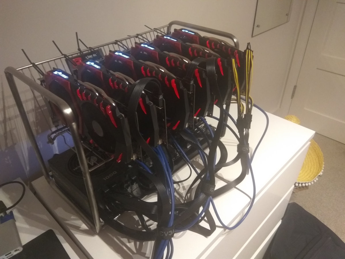 Ordning 1.0, a homemade cryptomining rig from 2017: six MSI Radeon RX 570 and RX 580 GPUs hanging from a metal rack over the power supply, sitting on top of a bedroom drawer in broad daylight